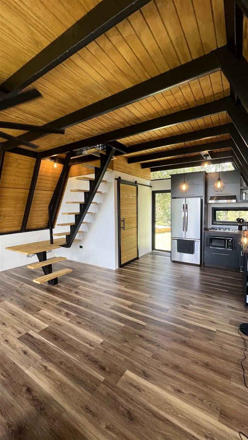 Escalera flotante de acero negro con peldaños de madera