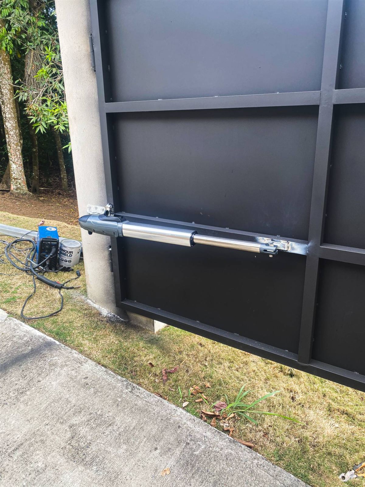 Motor de brazo instalado en un portón de abrir negro